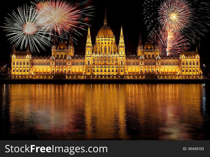 Fireworks exploding at night during News Years Eve celebration over Hungarian Parliament building with Danube river in foreground, Budapest, Hungary. Fireworks exploding at night during News Years Eve celebration over Hungarian Parliament building with Danube river in foreground, Budapest, Hungary.