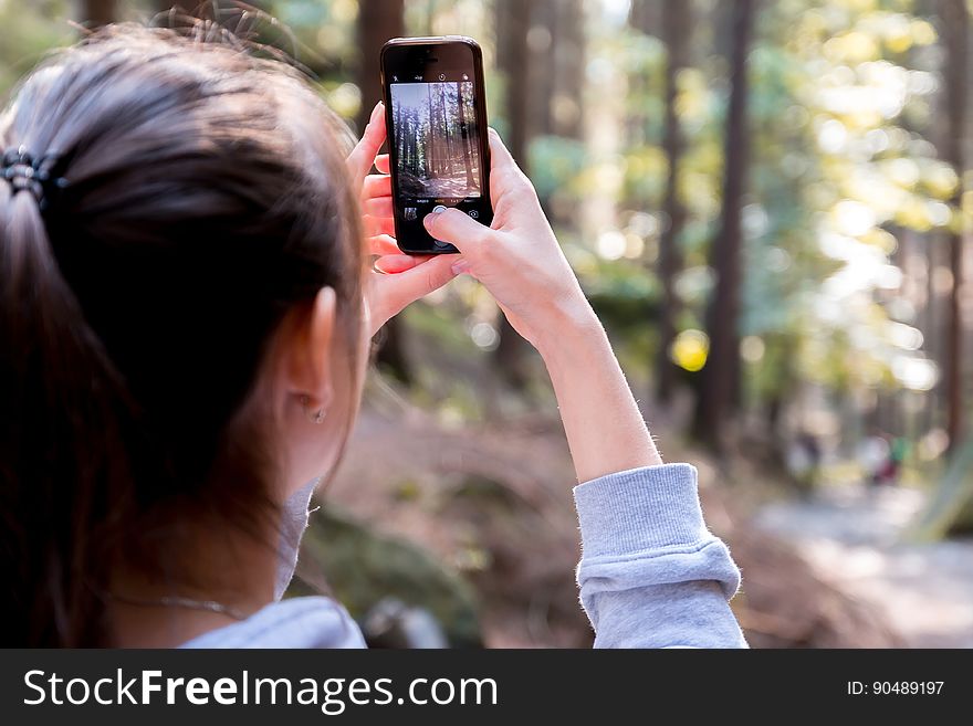 Woman Using Her Smartphone While Taking the Picture the Forest