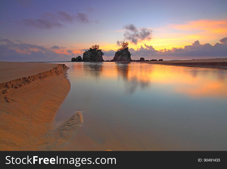 A sunrise or sunset on a sandy beach. A sunrise or sunset on a sandy beach.