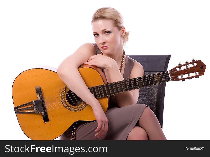 Woman with a guitar on a chair on a white background. Woman with a guitar on a chair on a white background