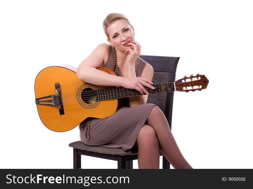 Woman with a guitar on a chair on a white background. Woman with a guitar on a chair on a white background