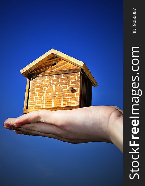 The house in human hand with blue sky. The house in human hand with blue sky