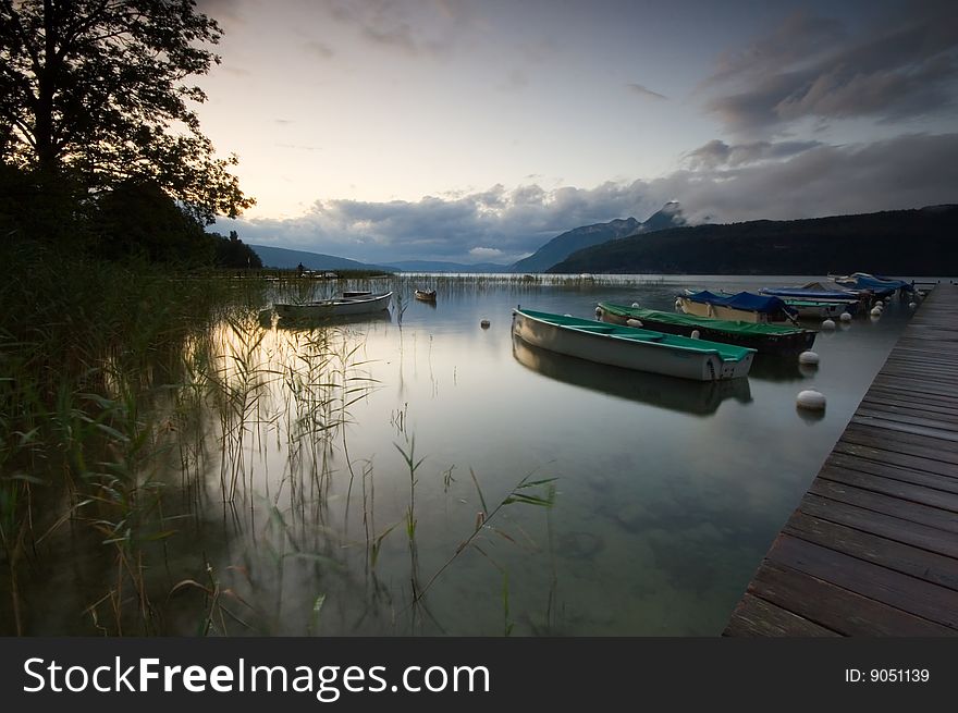 A landing stage and boat at sunrise at Lake Annecy France