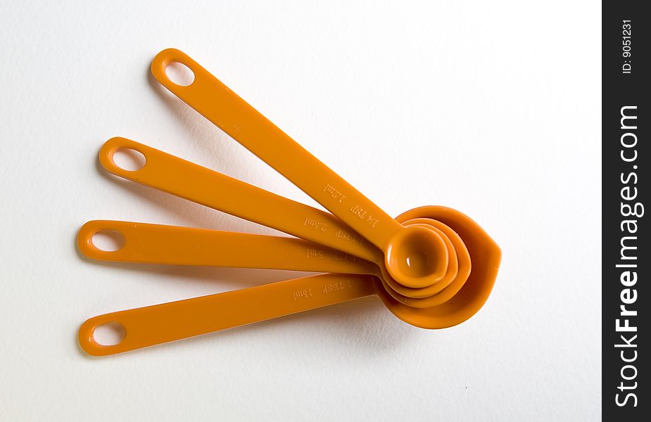 Orange measuring spoons, stacked