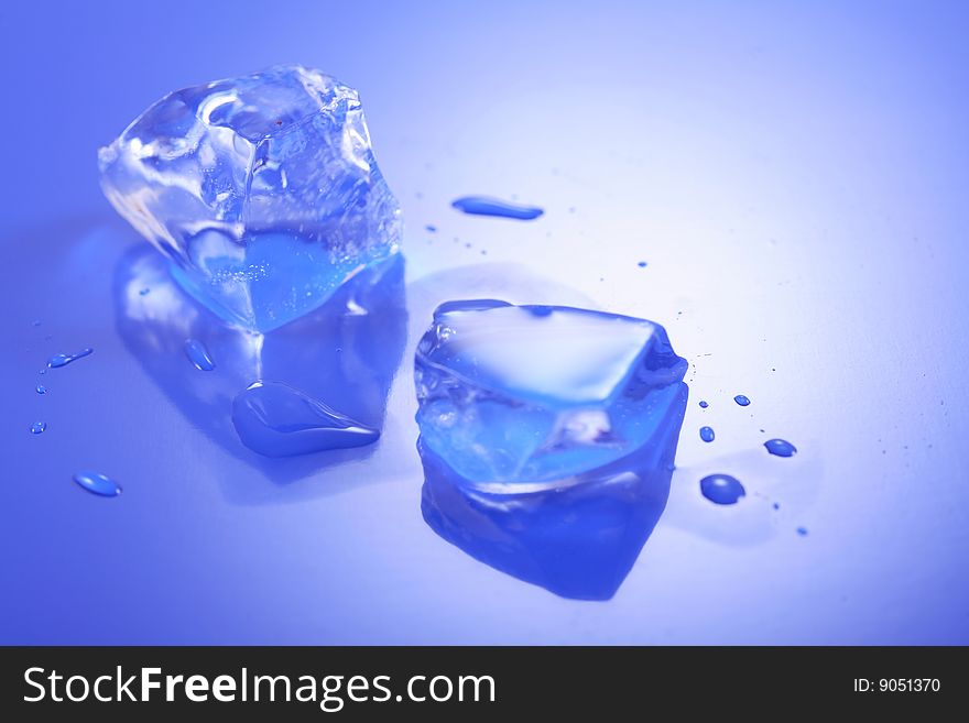 A image of Blue toned ice cubes on blue surface.