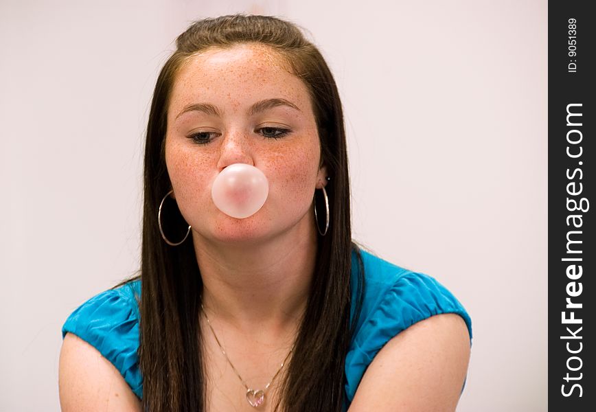 Girl blowing a pink bubble. Girl blowing a pink bubble