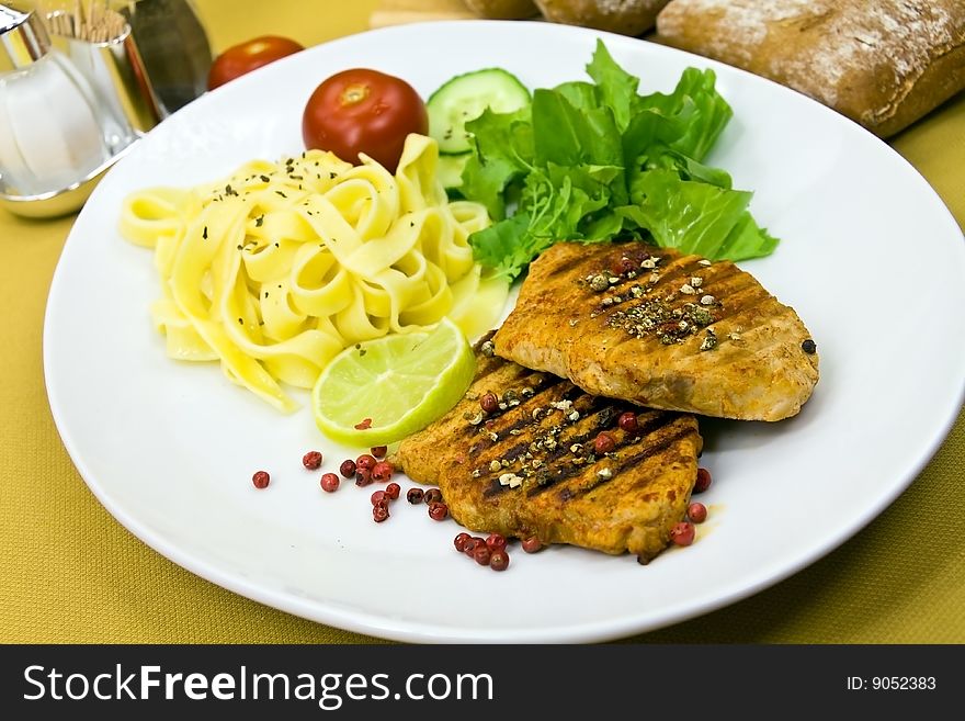 Grilled pork steak with noodles and lettuce.