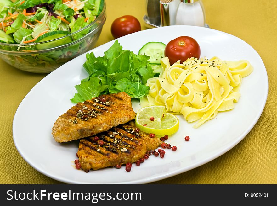 Grilled pork steak with noodles and lettuce.