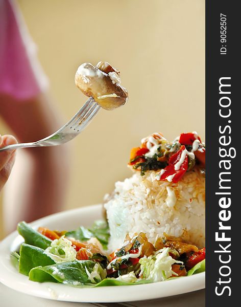 Appetizing rice dinner served, mushroom on fork. Appetizing rice dinner served, mushroom on fork