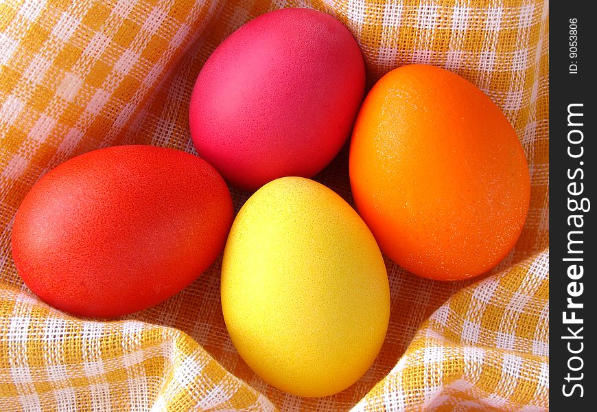 Traditional color Easter eggs on yellow checkers tablecloth