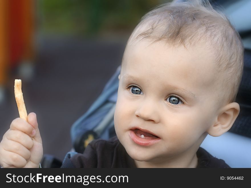 Sitting little boy about to eat a potato chip