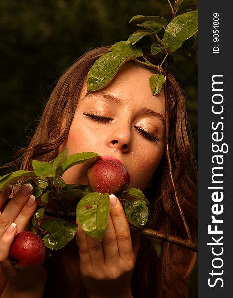 Woman eating apple with tree branch