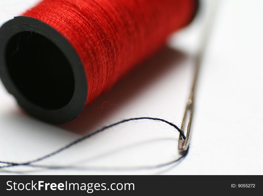 Needle and spool on the white background