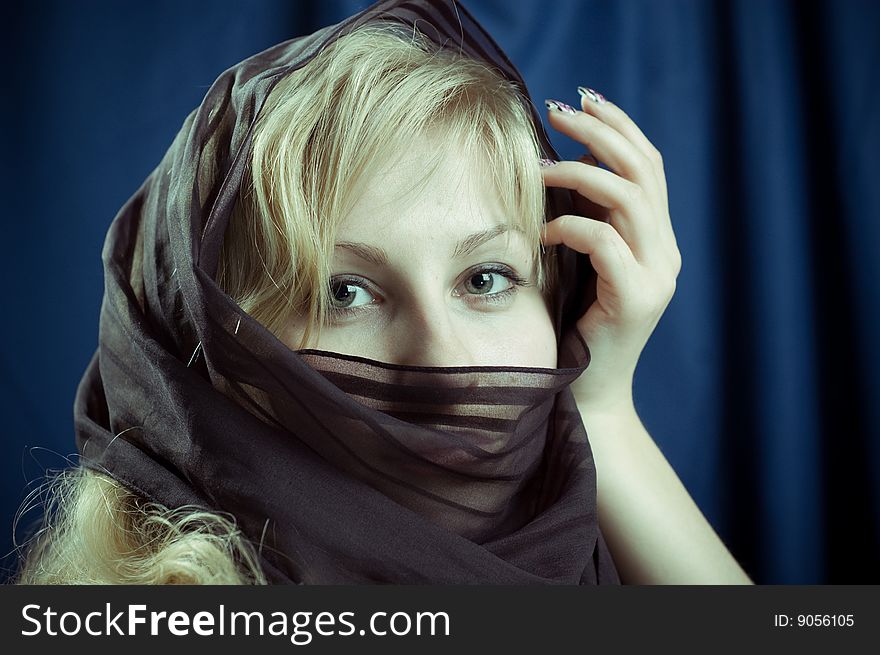 Close-up portrait of a young blonde girl in the dark blue background. Close-up portrait of a young blonde girl in the dark blue background