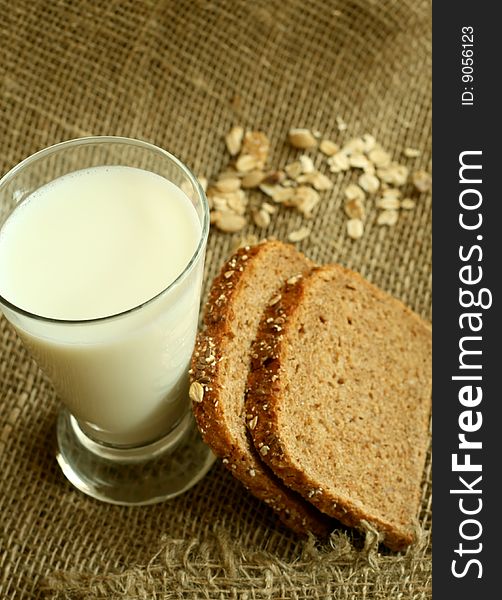 Glass of milk and bread on a sacking