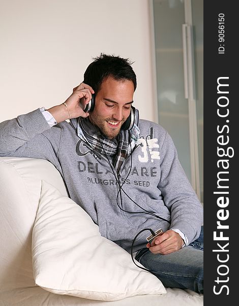 Man with headphones listening to music on an MP3 player.