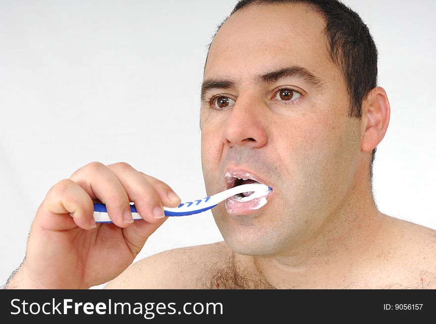 Man brushing his teeth isolated on gray background