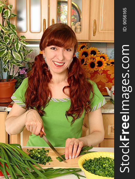 Process of cutting of a green onions in an interior of kitchen. Process of cutting of a green onions in an interior of kitchen