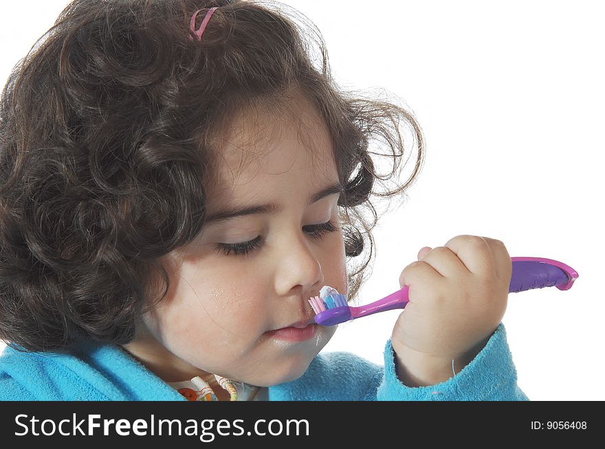 A little cute girl brushing the teeth isolated on white background