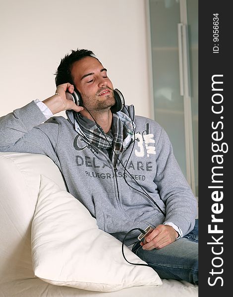 Man with headphones listening to music on an MP3 player. Man with headphones listening to music on an MP3 player.
