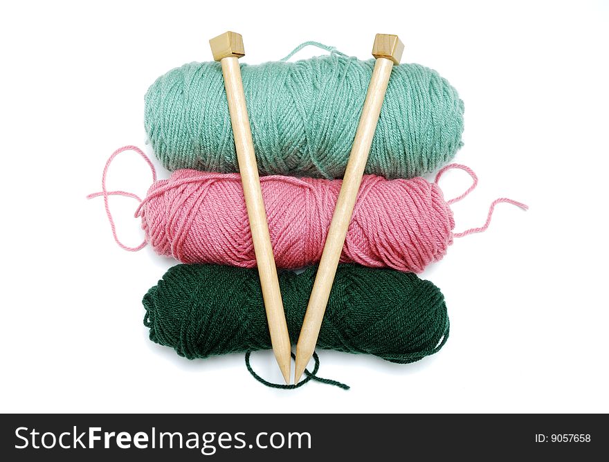 3 balls of colorful yarn with overlying thick wooden needles