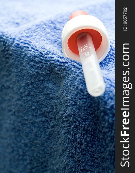 Medicine drops pipette for babies on blue towel. Medicine drops pipette for babies on blue towel