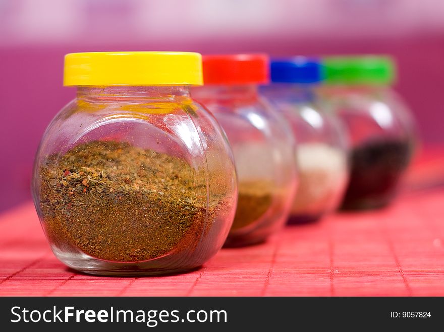 Four glass jars with spices and color covers