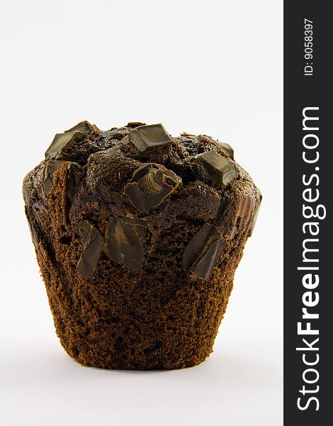 Single dark chocolate muffin with a white background. Single dark chocolate muffin with a white background