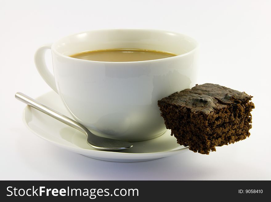 Cup of tea with dark chocolate brownie on a white background. Cup of tea with dark chocolate brownie on a white background