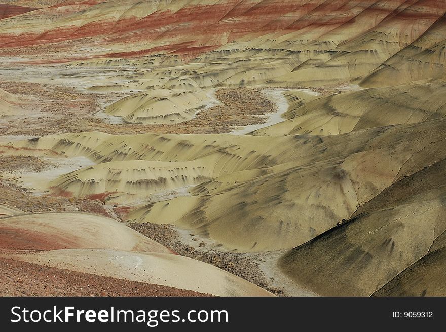 Painted Hills is one of the three units of the John Day Fossil Beds National Monument, located in Wheeler County, Oregon. It totals 3,132 acres (1,267 ha) and is located 9 miles (14 km) northwest of Mitchell, Oregon and 75 miles (121 km) east of Bend.Painted Hills is named after the colorful layers of its hills corresponding to various geological eras, formed when the area was an ancient river floodplain.

The black soil is lignite that was vegetative matter that grew along the floodplain. The grey coloring is mudstone, siltstone, and shale. The red coloring is laterite soil that formed by floodplain deposits when the area was warm and humid.