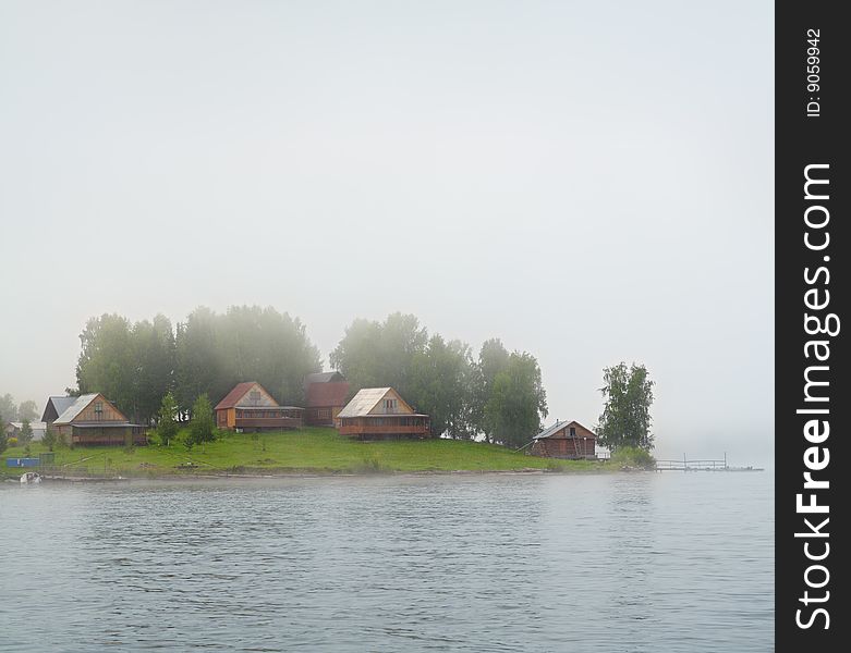 Settlement on lake island in fog