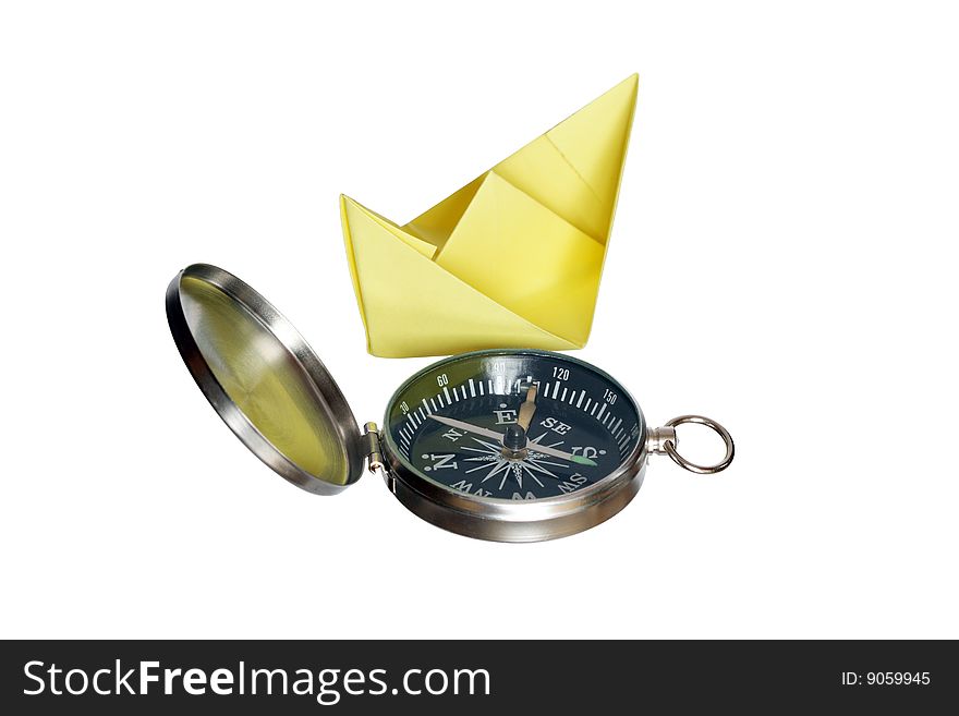 Yellow paper boat standing near compass isolated on white background with clipping path. Yellow paper boat standing near compass isolated on white background with clipping path