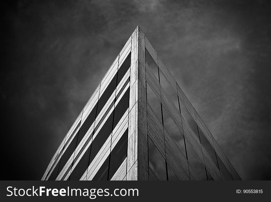 A low angle perspective view of the corner of a building in monochrome.
