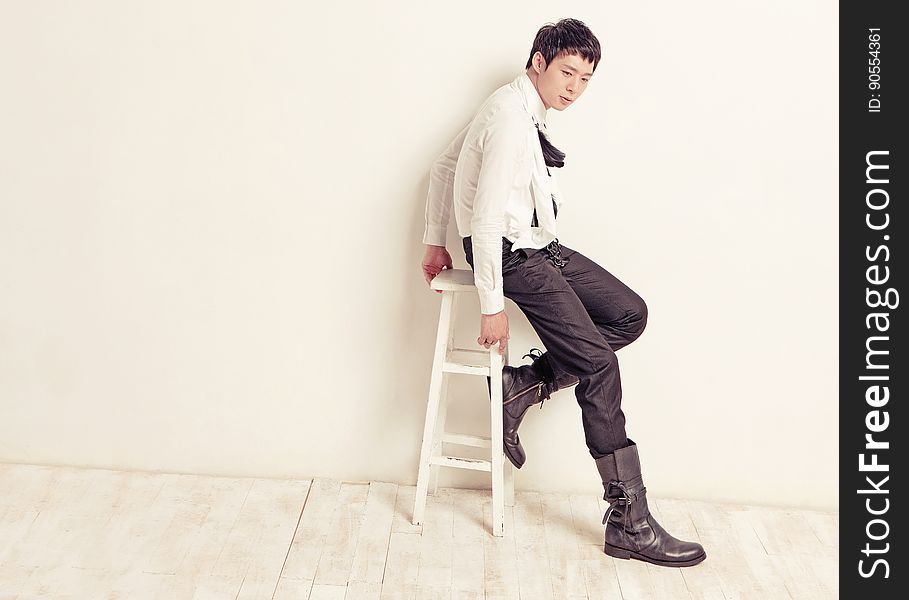 A boy in casual clothing posing on a chair. A boy in casual clothing posing on a chair.