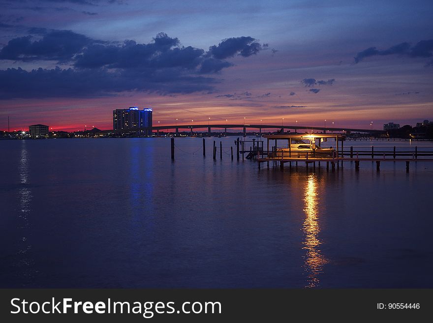 A sunset with a pier with a light. A sunset with a pier with a light.