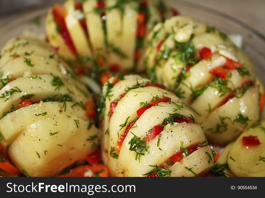 Hasselback potatoes with herbs and vegetables.