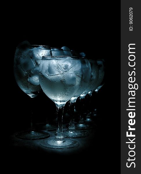 Glasses with ice cubes isolated over black background. Glasses with ice cubes isolated over black background