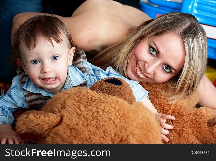 Child, baby boy, and his mother, happy, play with teddy bear. Child, baby boy, and his mother, happy, play with teddy bear