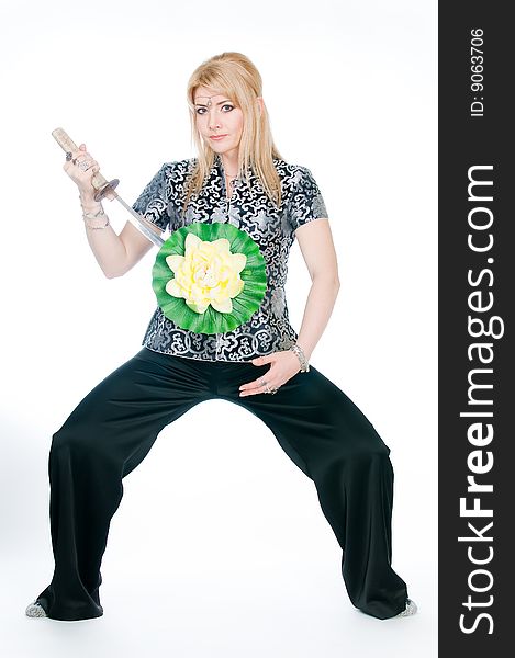 Woman with sword and lotus flower, studio shot