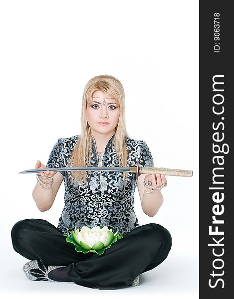 Woman sitting in lotus pose with katana, isolated on white background