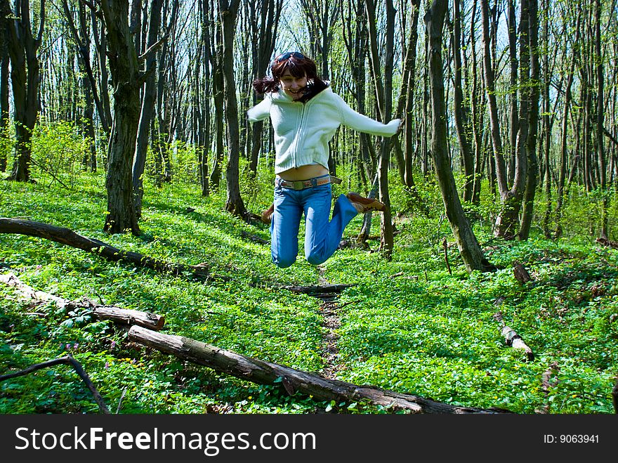 Jumping girl in a forest path