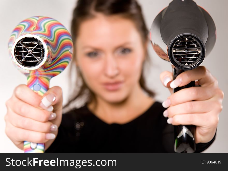 Young attractive woman with two hairdryers. Young attractive woman with two hairdryers