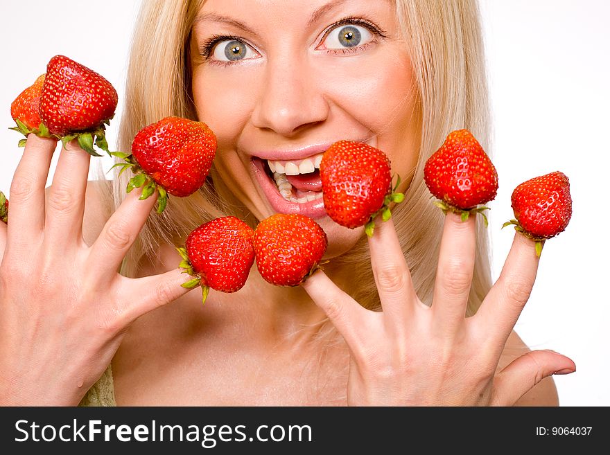 Sweet caucasian girl eating strawberries picked on fingertips