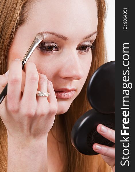 Nice caucasian model applying makeup with brush. Nice caucasian model applying makeup with brush