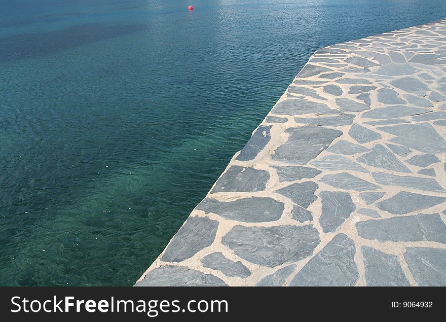 Blue sea and a stone promenade at the coast. Blue sea and a stone promenade at the coast