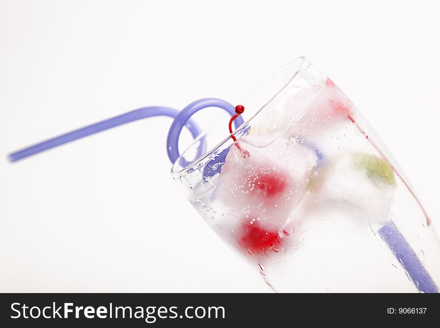 Glass of water with frozen fruit inside the ice cube. Glass of water with frozen fruit inside the ice cube