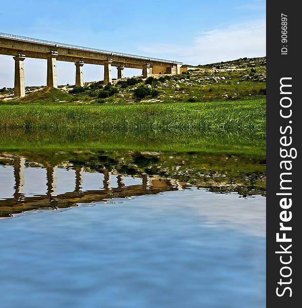 A hige long train bridge reflected in the river