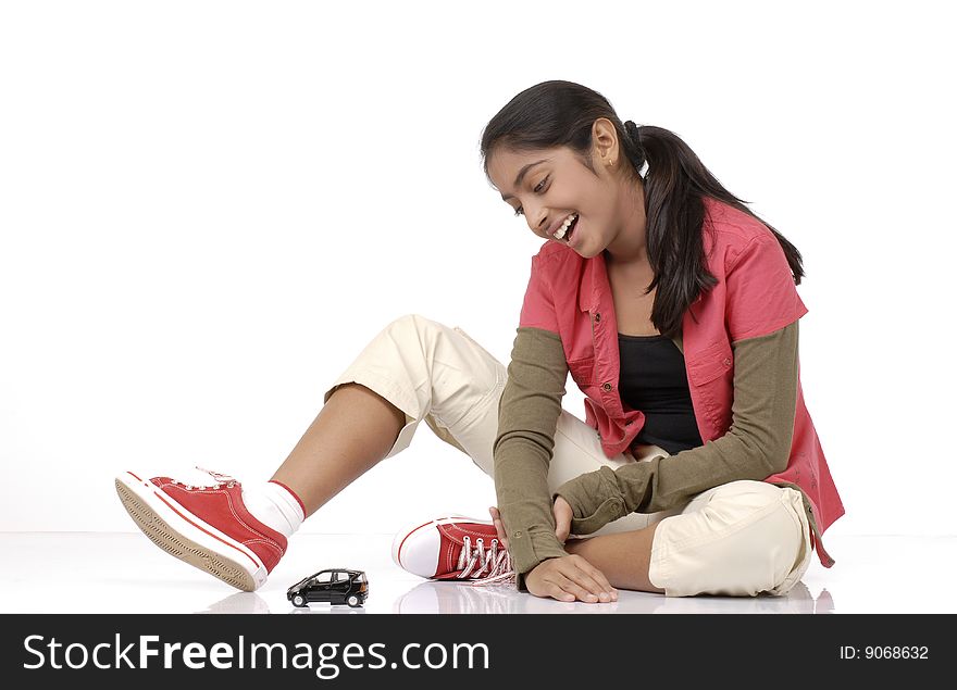 Beautiful girl looking at car model over white background. Beautiful girl looking at car model over white background