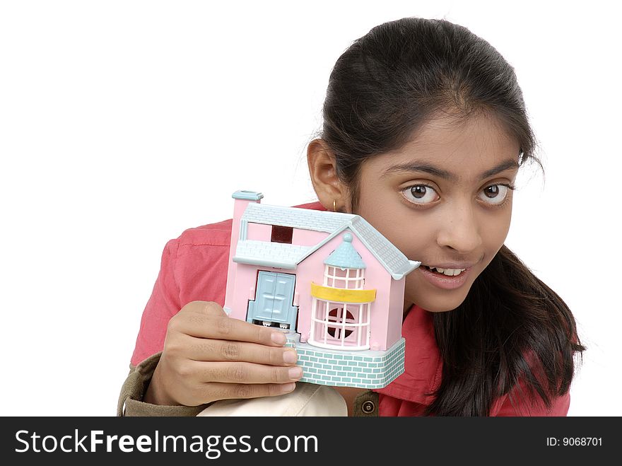 Beautiful girl holding dream model house over white background. Beautiful girl holding dream model house over white background