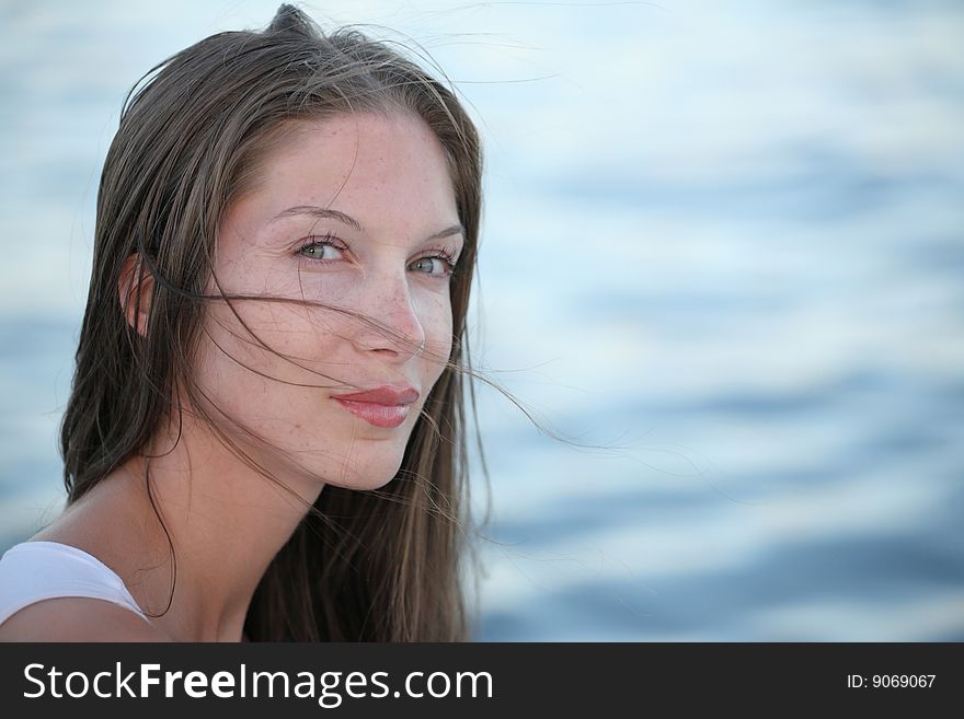 Portrait of beautiful young woman on water background